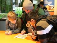 Teacher Scott McGuyer (a.k.a. Night Hawk) pauses to look at a map while students Dylan Bomar, left, Damian Garcia look on.