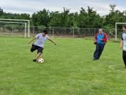 Incoming eighth-grader Brian Reyes kicks an incoming goal as staff Adrian Tapia, left, and Ben Bonser look on.