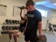 Seniors Josiah Texta, left, and Kamron Anderson build their strength for the football season on a chilly afternoon.