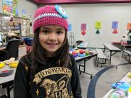 Second-grader April Campos Gomez thought all of Grandma J’s hats were cute. Photo by Jillian Daley