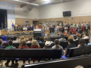 Students watching their classmates sing