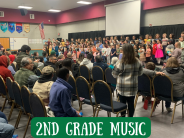 Students singing, parents watching in audience