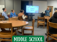 Teacher presenting next to a screen