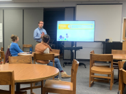 Teacher presenting next to a screen
