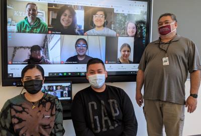 SAFE co-founder Bill Graupp stands with students and co-founder Ty Brack (on the screen).