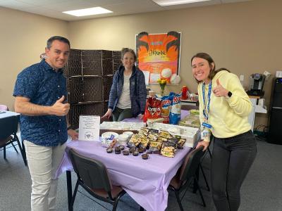 PTO President Sara Hughes stands in the back of the room as two Primary School teachers grin over the gifts the PTO brought!