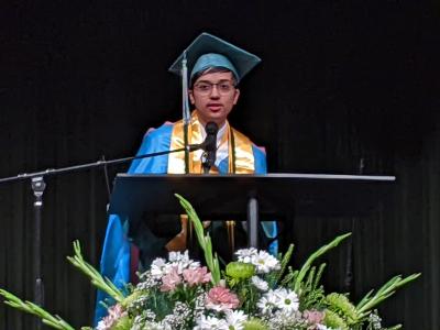 A valedictorian speaks at the podium during commencement in 2022