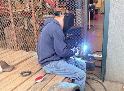 Sophomore Henry Kirsch practices welding under the watchful eye and guidance of Teacher Damian Trammel. Photo by Damien Trammel