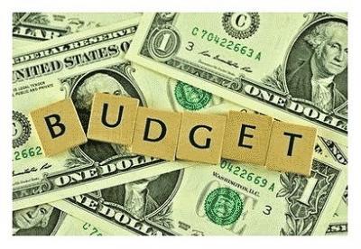 Budget pic with scrabble tiles on top of cash