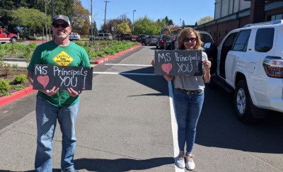 School Principals Tami Badinger and David Sheldon greet students during a recent event