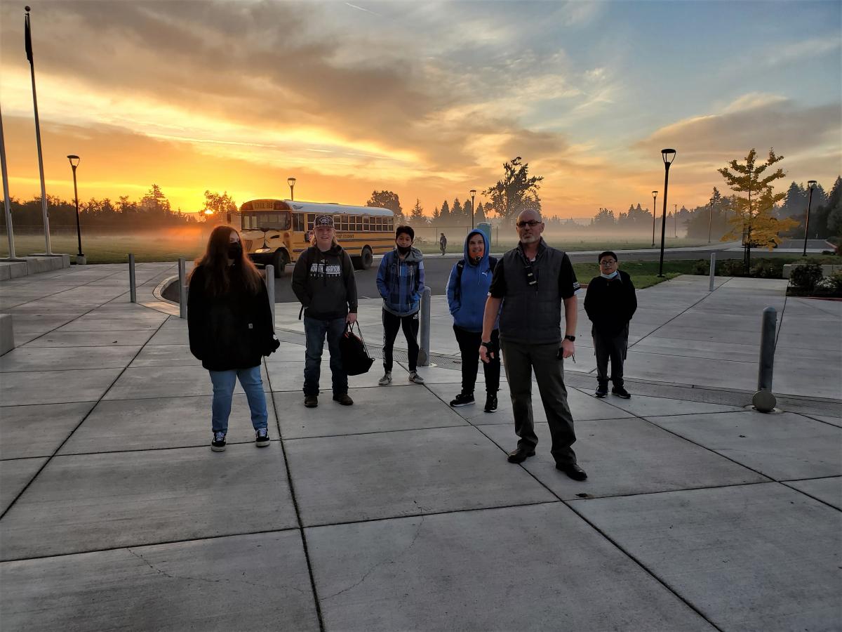 Principal David Sheldon stands proudly with his students during a vibrant sunrise on Tuesday, October 19.