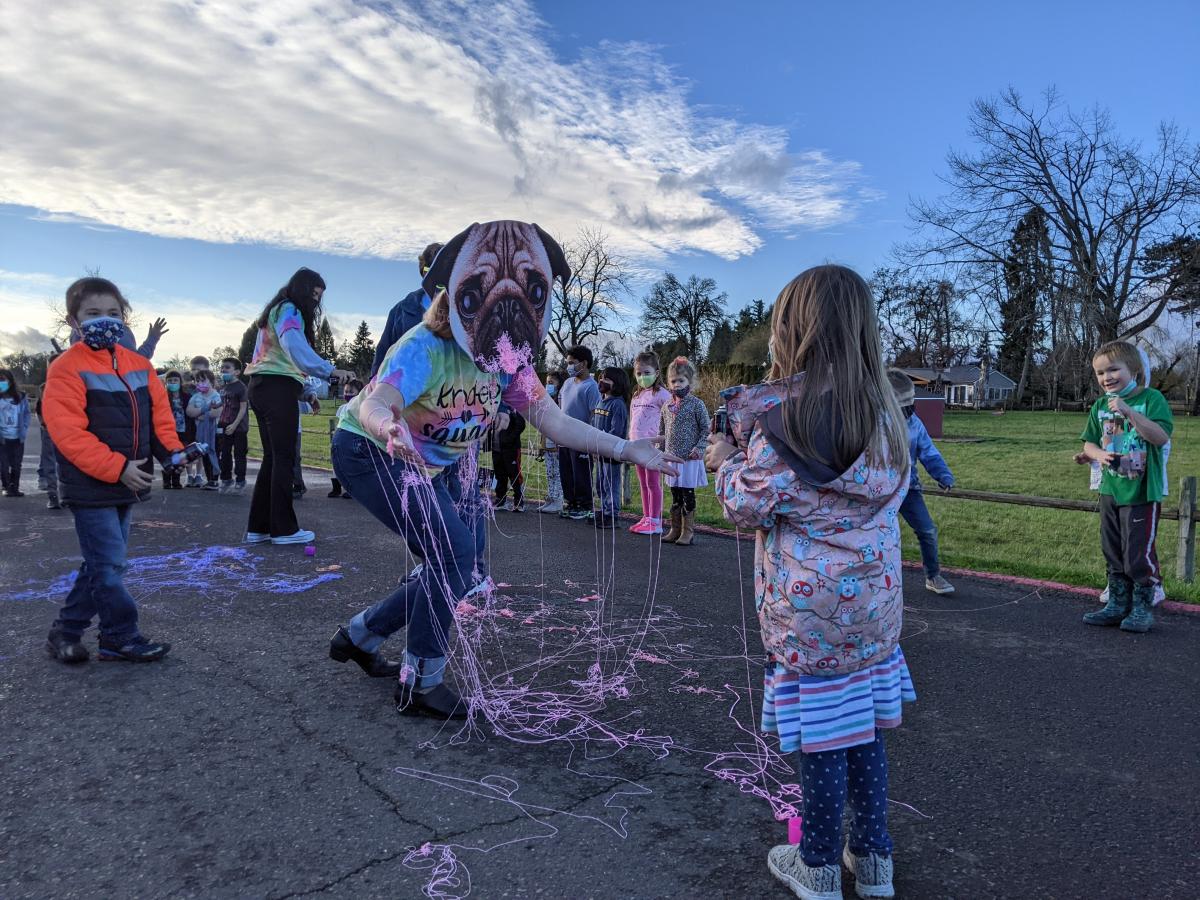 Kindergartner Ellie Jo Hansen unleashes a spider’s web of Silly String upon Teacher Emily Miller wile Jones Quintero looks on. 