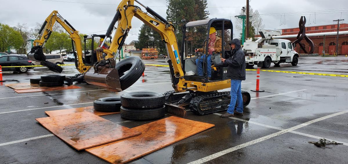 Senior Caedyn Laninga hoists tires with a backhoe under the direction of an experienced worker. Photo by Sherie Moran