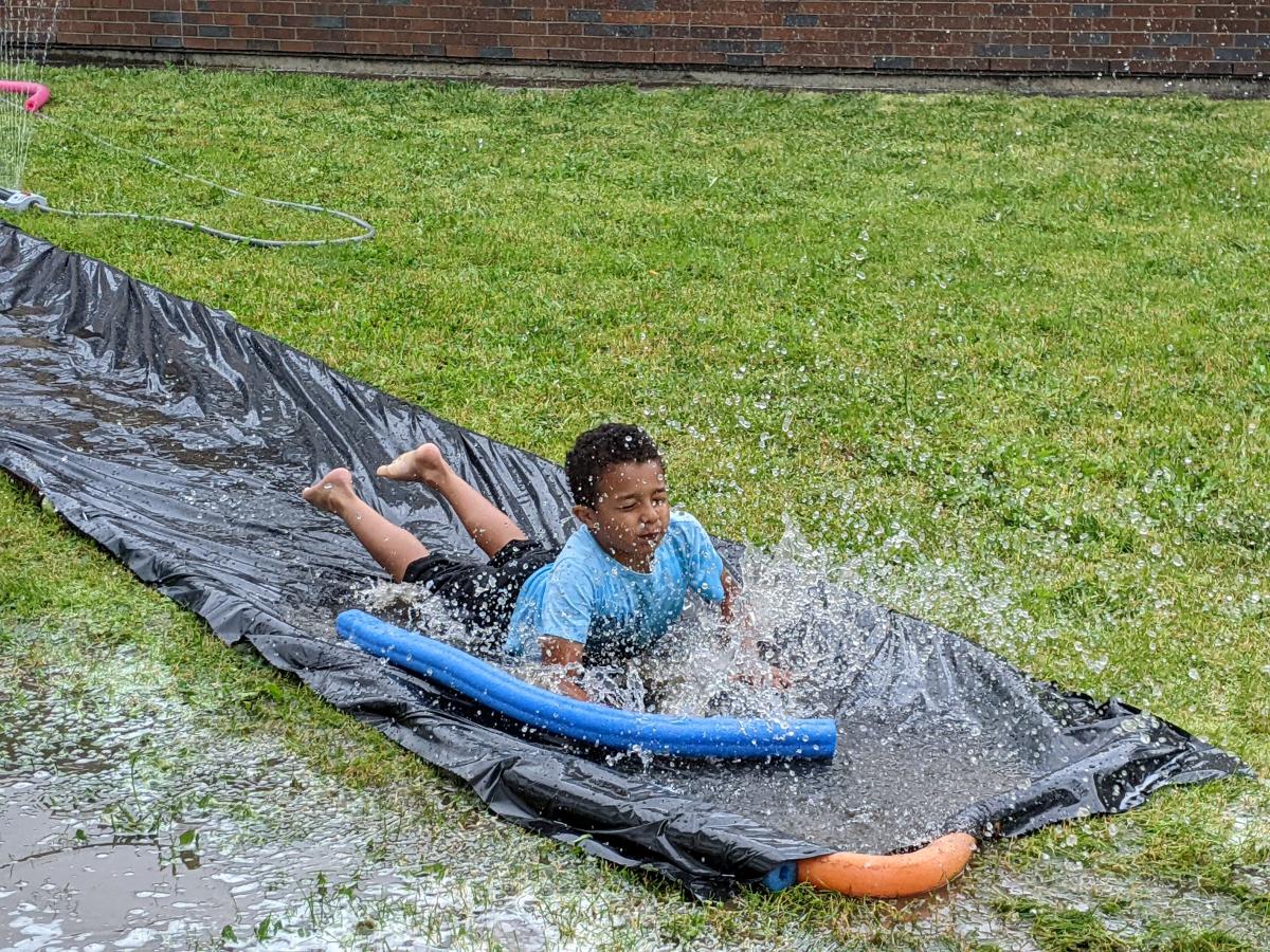 First-grader Xzavion Henry is dousing his “Que Pasa, Ladies?” shirt while rushing down the water slide during Field Day.