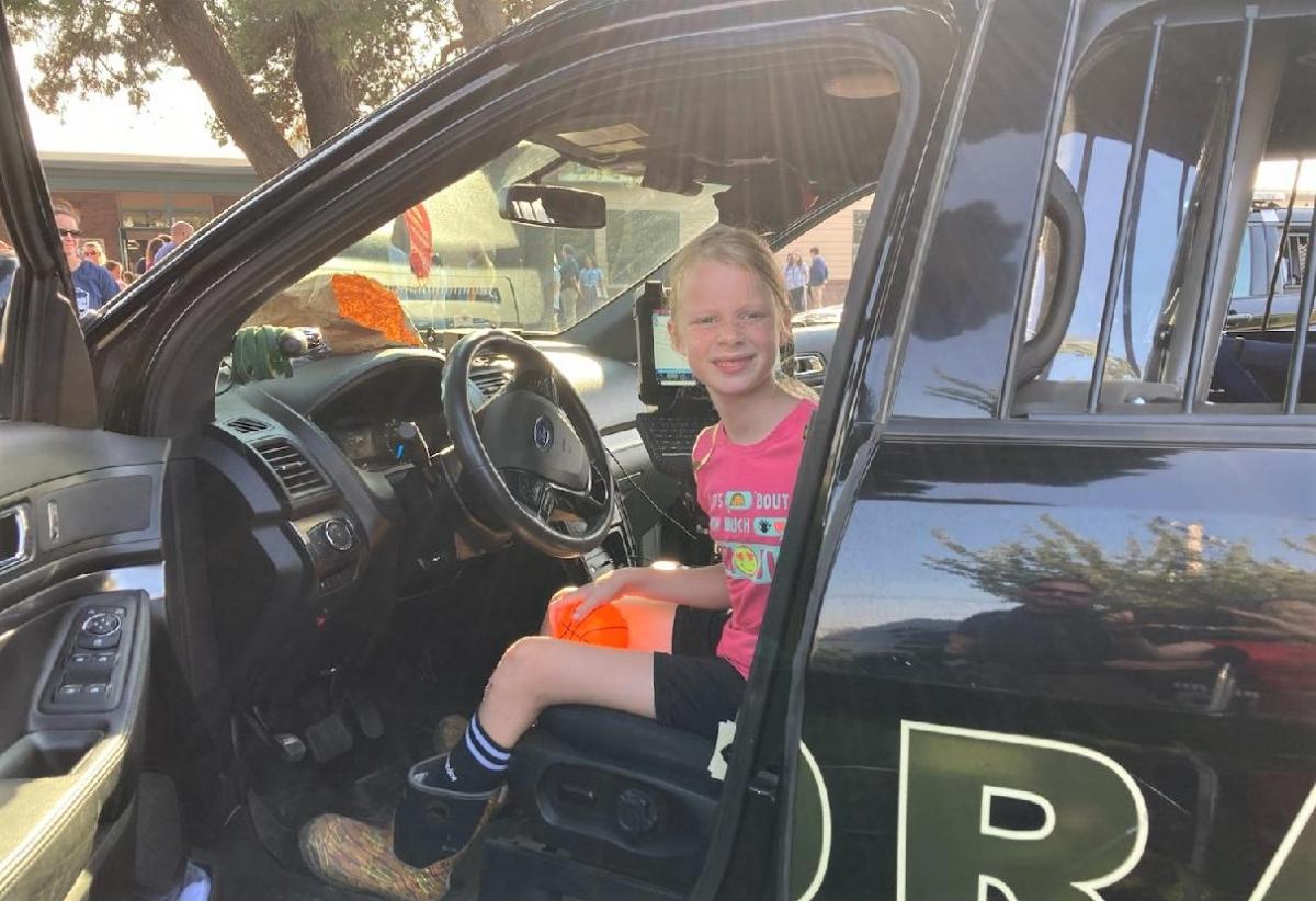 Fifth-grader Joan Bonser takes a moment to enjoy a real police cruiser. Photo by MCSO Deputy Pete Walker