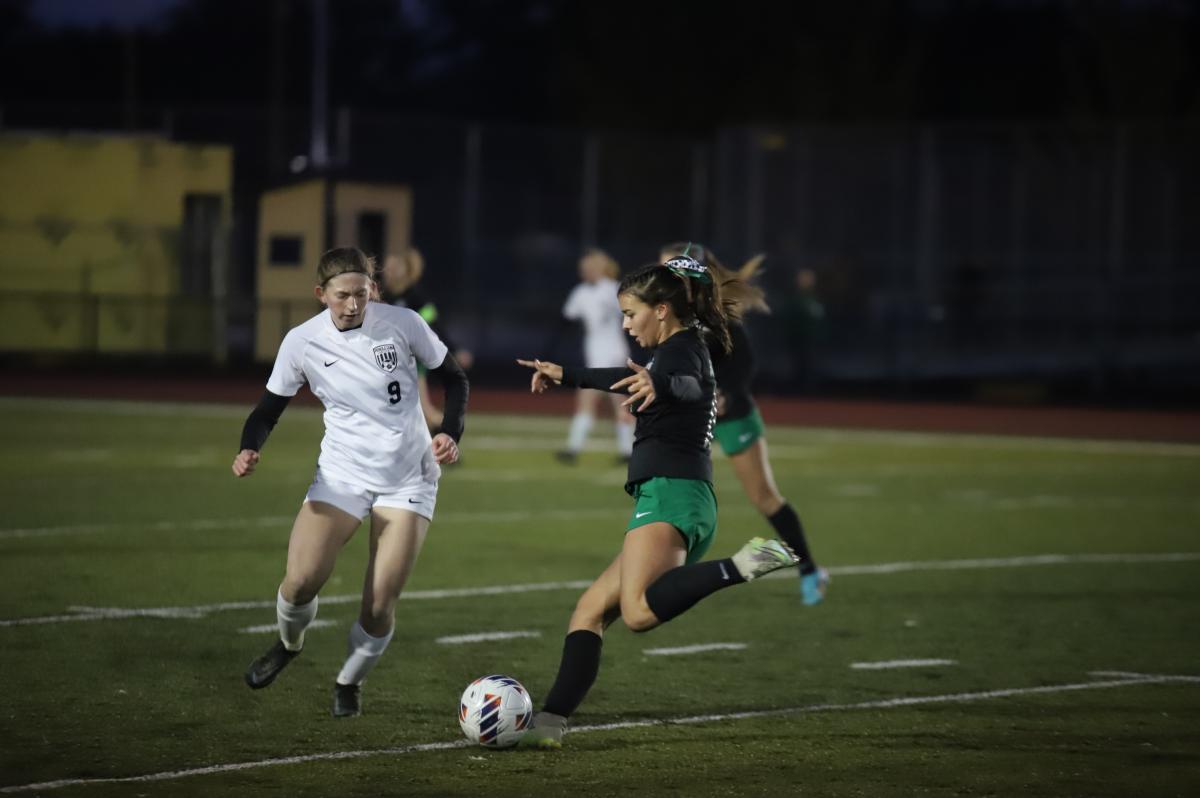 Paige Comerford dribbles down the field, while a Pendleton player strives to gain control of the ball. Photo by Natalie Parmente