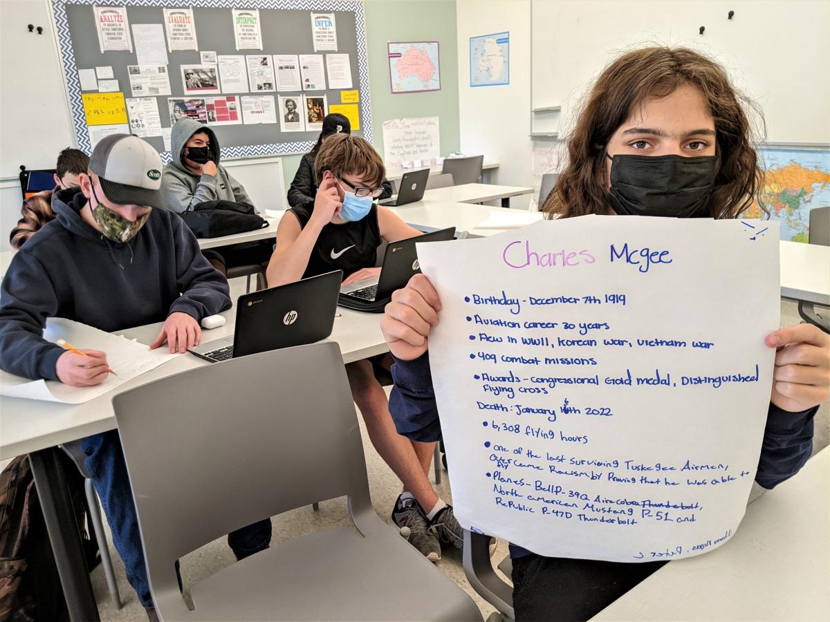 North Marion High School ninth-grader Peter Crosby holds up his poster on one of the Tuskegee Airmen, Brigadier General Charles 