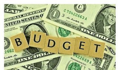 Budget pic with scrabble tiles on top of cash