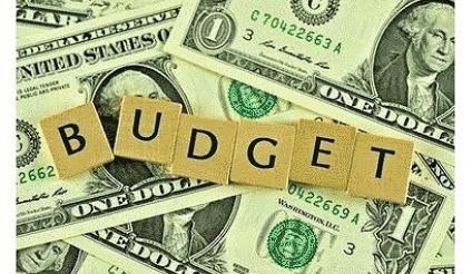 Picture of cash money with word budget spelled out with scrabble tiles